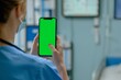 © Rade Kolbas - Medical Professional Evaluating Healthcare Applications on a Green Screen Smartphone in Hospital Setting