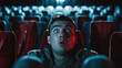 Young man watching horror movie in the cinema. Shocked expression.