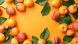 Apricots with leaves arranged on an orange background, viewed from the top in a flat lay style
