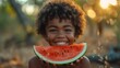 Afro boy smiles eating a piece of watermelon in summer