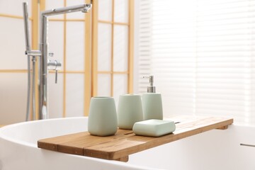 Set of bath accessories on tub in bathroom