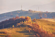 Panoramic view of misty sunny autumn evening in mountains. Beautiful sunset hills landscape. Slopes, meadows, fields, village, house, dirt road. Amazing fall rural scene. Carpathian range.