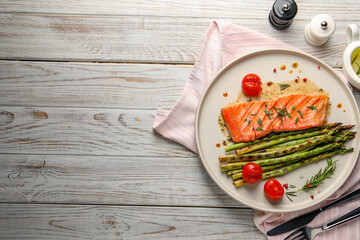 Wall Mural - Tasty grilled salmon with tomatoes, asparagus and spices served on wooden table, flat lay. Space for text