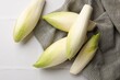 Fresh raw Belgian endives (chicory) on white tiled table, top view