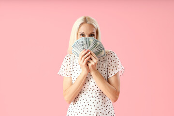 Poster - Mature woman with dollar banknotes on pink background