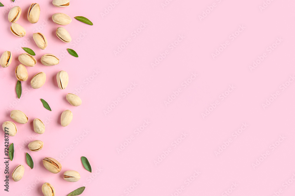 Tasty pistachio nuts and leaves on pink background