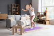 © Pixel-Shot - Sporty young African-American woman jumping with rope in living room