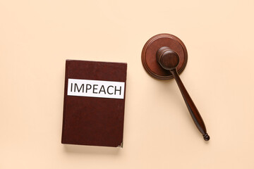 Judge gavel, book of law and word IMPEACH on beige background