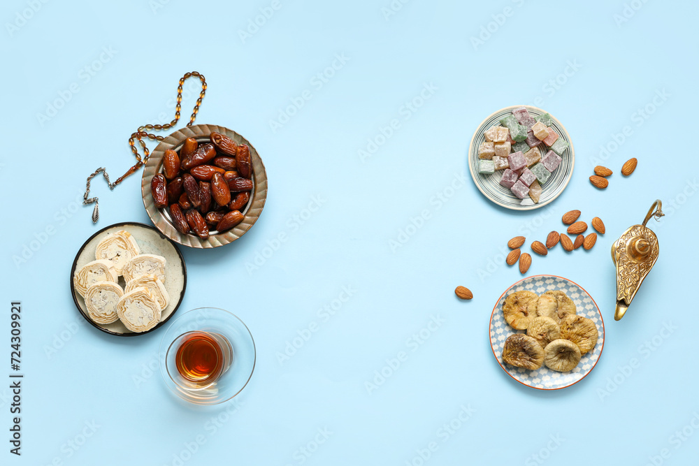Composition with traditional Eastern sweets, Aladdin lamp and tasbih for Ramadan on color background