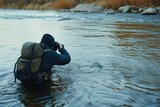 Fototapeta Do akwarium - Nature photographer shooting a scene in a river.