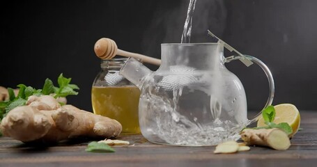 Wall Mural - Hot boiling water pours into glass tea pot with teabag