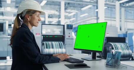 Fototapete - Female Caucasian Software Developer Working on a Desktop Computer with Green Screen Chromakey On Display At an Industrial Plant. Technological Research and Development Office Monitoring the Production