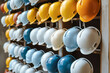 © Iurii - Multicolored construction helmets hanging on a wooden wall. Generative AI