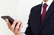 © 木村　亨 - 片手にスマートフォンを持つスーツ姿の男性