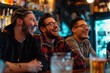 Three young men laughing at the bar, looking happy at soccer games
