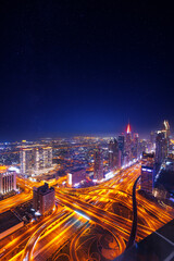 Wall Mural - Night cityscape of center Dubai, aerial top view. Skyscrapers illuminated and highway of UAE