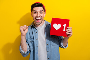 Poster - Photo of funky lucky guy wear denim jacket rising fist showing positive heart like card isolated yellow color background