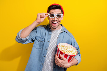 Canvas Print - Photo of cheerful excited man dressed jeans shirt eating pop corn enjoying 3d film isolated yellow color background