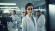 Beautiful young woman scientist wearing white coat and glasses in modern Medical Science Laboratory