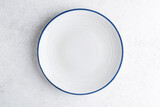 Fototapeta Desenie - Empty white plate with blue corner. Top view copy space
