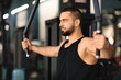 © Prostock-studio - Concentrated man in tank top exercising on chest press machine at gym