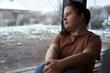 © gpointstudio - Thoughtful down syndrome woman sitting next to window and looking away