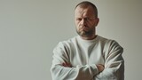 Fototapeta  - Magazine cover featuring a 40 years old man in a sweatshirt, displaying a worried and angry facial expression against a white background.