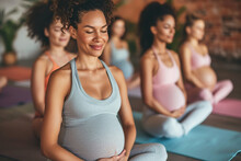 Group of expecting moms in a prenatal yoga class, smiling and practicing wellness