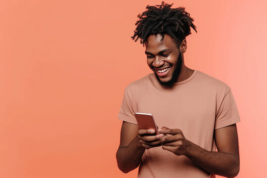 Casual African American man on peach background using smartphone