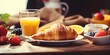 A delicious breakfast spread featuring a croissant, orange juice, and fresh strawberries. Perfect for starting your day off right.