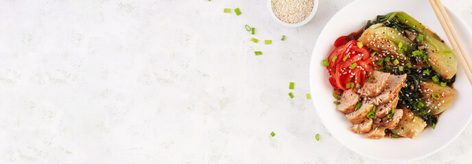 Wall Mural - Stir fried of chicken, sweet peppers and bok choy in a bowl on the table. Stir fry pak choi. Asian food. Top view