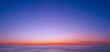 Idyllic natural sunrise sky background over sea in the early morning with motion blur of flowing water surface in panoramic view, beautiful tranquil seascape view in sunset time 