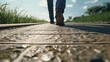 A person is walking across a wooden walkway. This image can be used to depict a peaceful outdoor scene or as a metaphor for a journey or progression