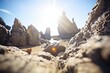 sun spots seen through craggy rocks on a coastline