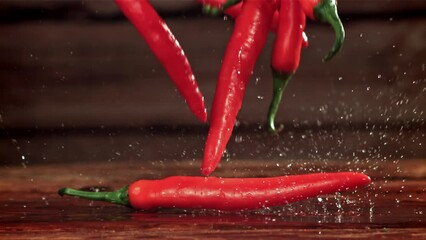 Wall Mural - Chili peppers fall on a wooden board. Filmed on a high-speed camera at 1000 fps. High quality FullHD footage