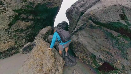 Sticker - Man Climbing onto Wet Rocks to Pass Sea Stack along the coast in Redwood National Park