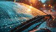Car windshield with rain drops and frameless wipers.