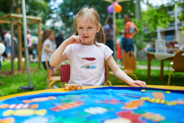 Wall Mural - preschooler girl playing board game outdoors