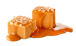 Two salty caramel candy cubes topped with caramel sauce and salt on white background
