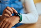 Fototapeta  - Close-up of a black female using a smartwatch, wearing around the wrist.
