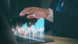 © PRIM - 2024 business target goal finance technology and investment stock market trading concept. businessman holding virtual graph icon analysing forex or crypto currency trading graph financial data.
