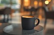 A minimalist, matte black coffee cup, filled with freshly brewed coffee, placed on a sleek, stone table in a well-lit, modern restaurant.