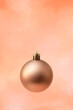 golden christmas ball on an orange background