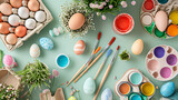 Fototapeta Uliczki - A flat lay of a DIY Easter craft table with paints brushes and egg decorating materials.