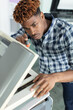 a young man is fixing a printer