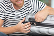 close up picture of a man zipping his suitcase
