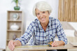 happy elderly woman measuring a furniture