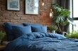 Urban comfort: Modern bedroom boasts bed with blue pillow and coverlet by fireplace, set against a rustic brick wall in loft interior design.