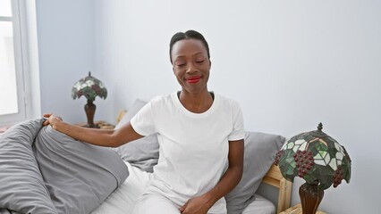 Wall Mural - Smiling african american business woman welcoming success, offering a friendly handshake while lying in comfort of bedroom