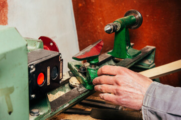 Wall Mural - A carpenter works in a workshop with a saw, planer and various tools